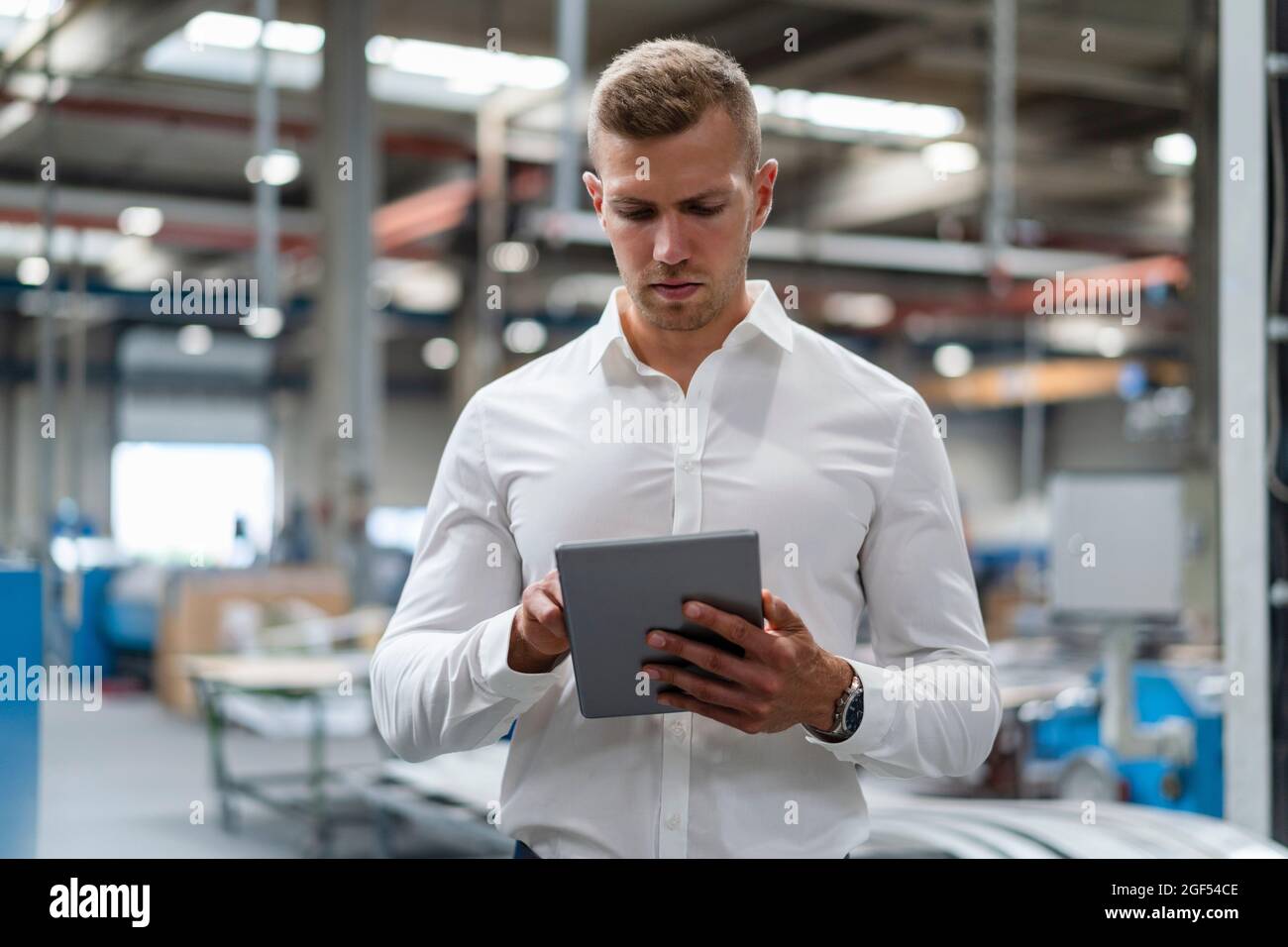Young businessman using digital tablet at industry Stock Photo