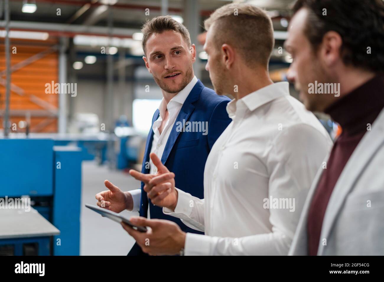 Male professionals discussing while working at industry Stock Photo