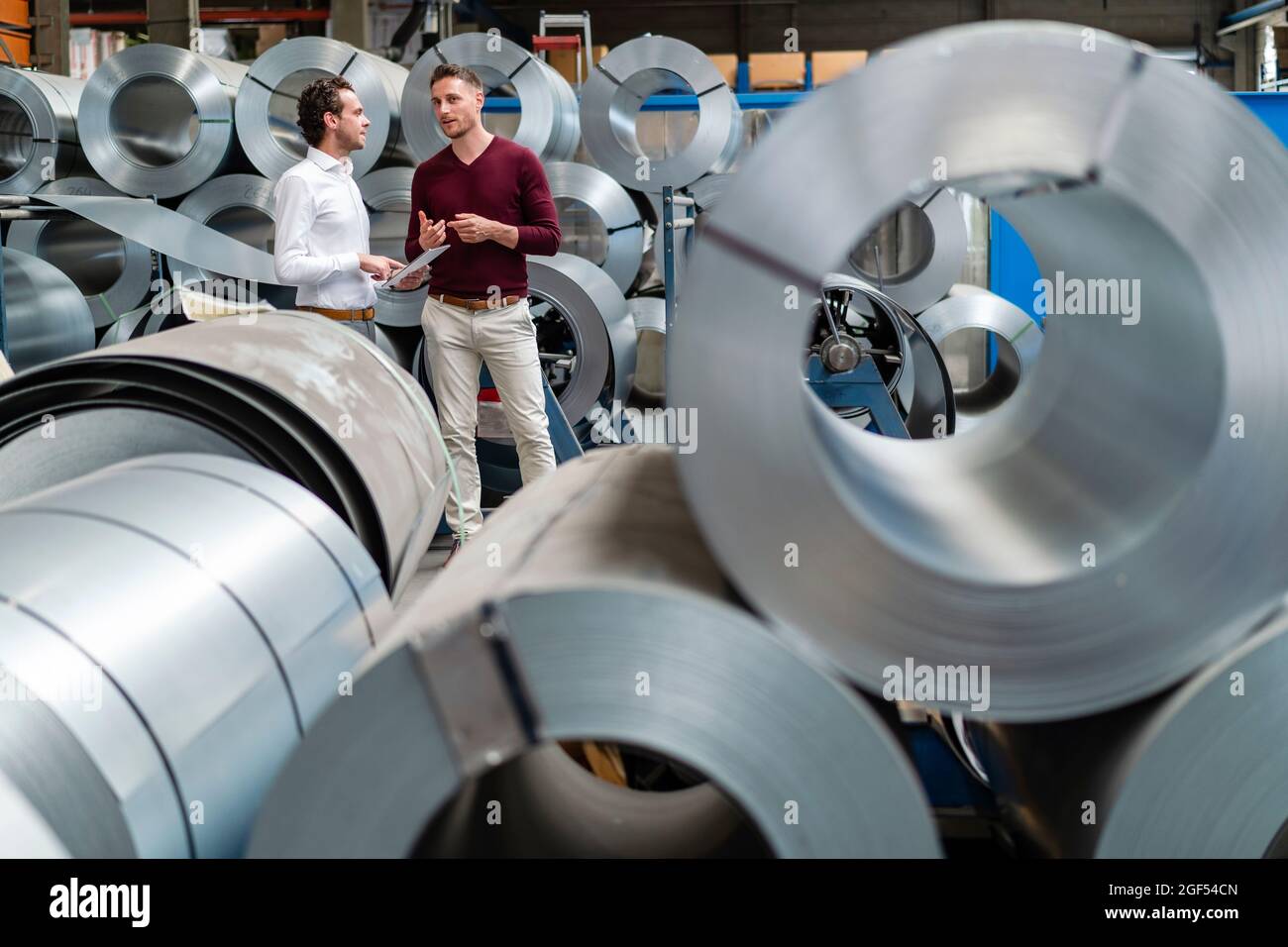 Male professionals discussing while working at industry Stock Photo