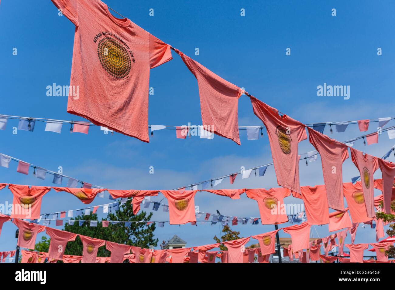 Halifax, Nova Scotia, Canada - 10 August 2021: Orange shirts hang at the Halifax waterfront to honour Indigenous children forcibly taken to residentia Stock Photo
