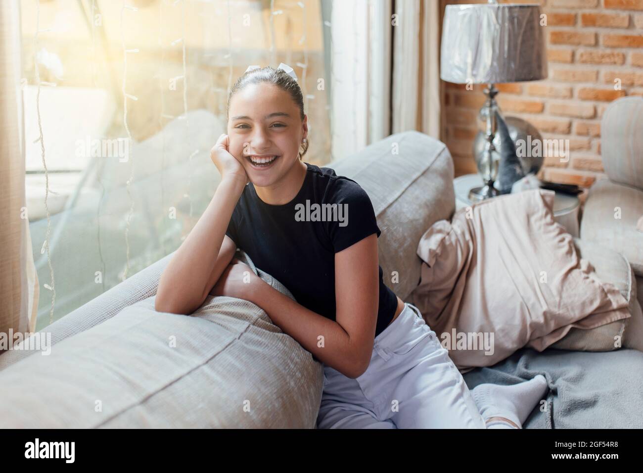 Happy child girl sitting sofa hi-res stock photography and images - Alamy