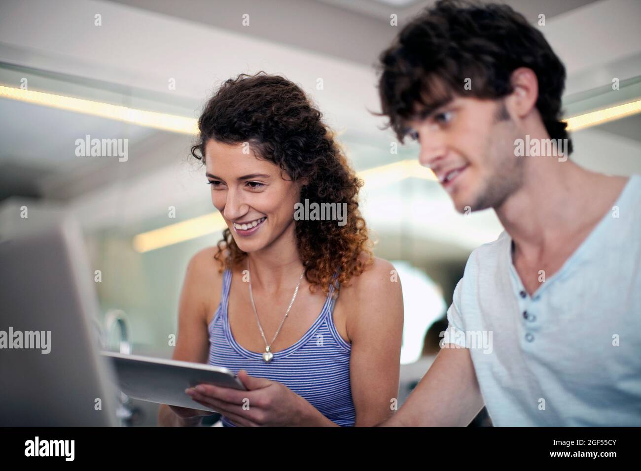 Man and woman using technologies in kitchen at home Stock Photo