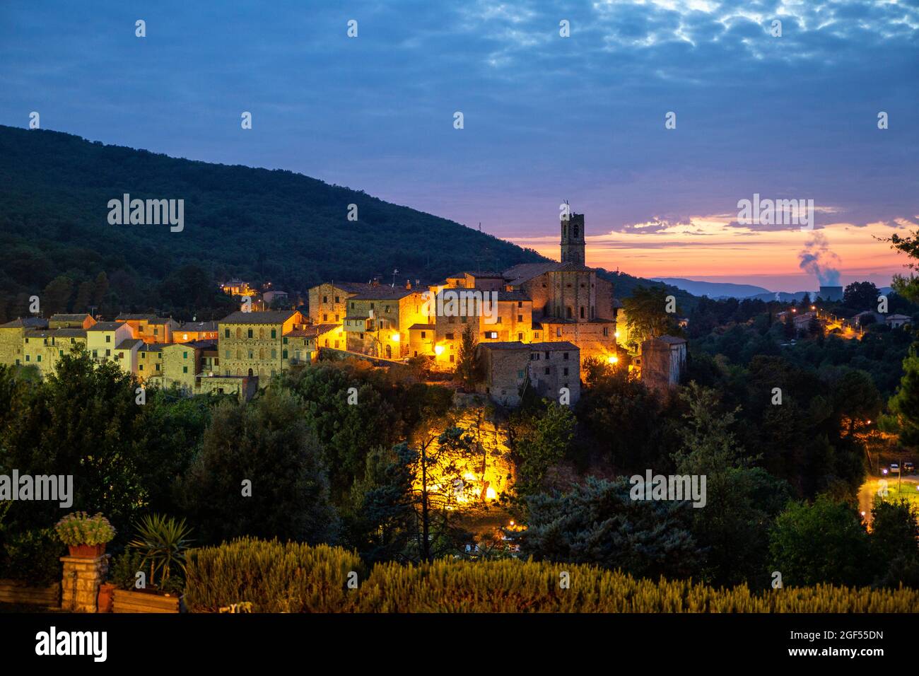 Italy, Province of Pisa, Sasso Pisano, Illuminated village at dusk Stock Photo
