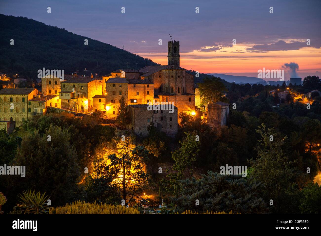 Italy, Province of Pisa, Sasso Pisano, Illuminated village at dusk Stock Photo
