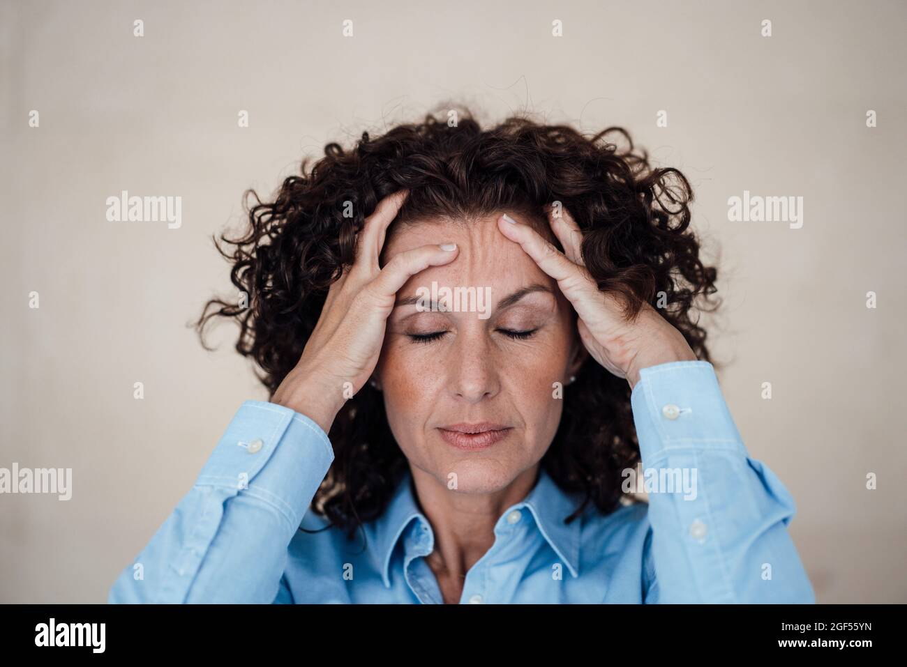 Overworked businesswoman with eyes closed at office Stock Photo