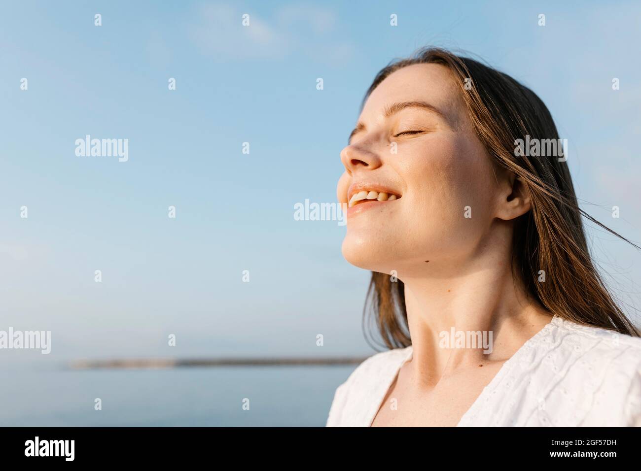 Smiling beautiful young woman with eyes closed Stock Photo - Alamy