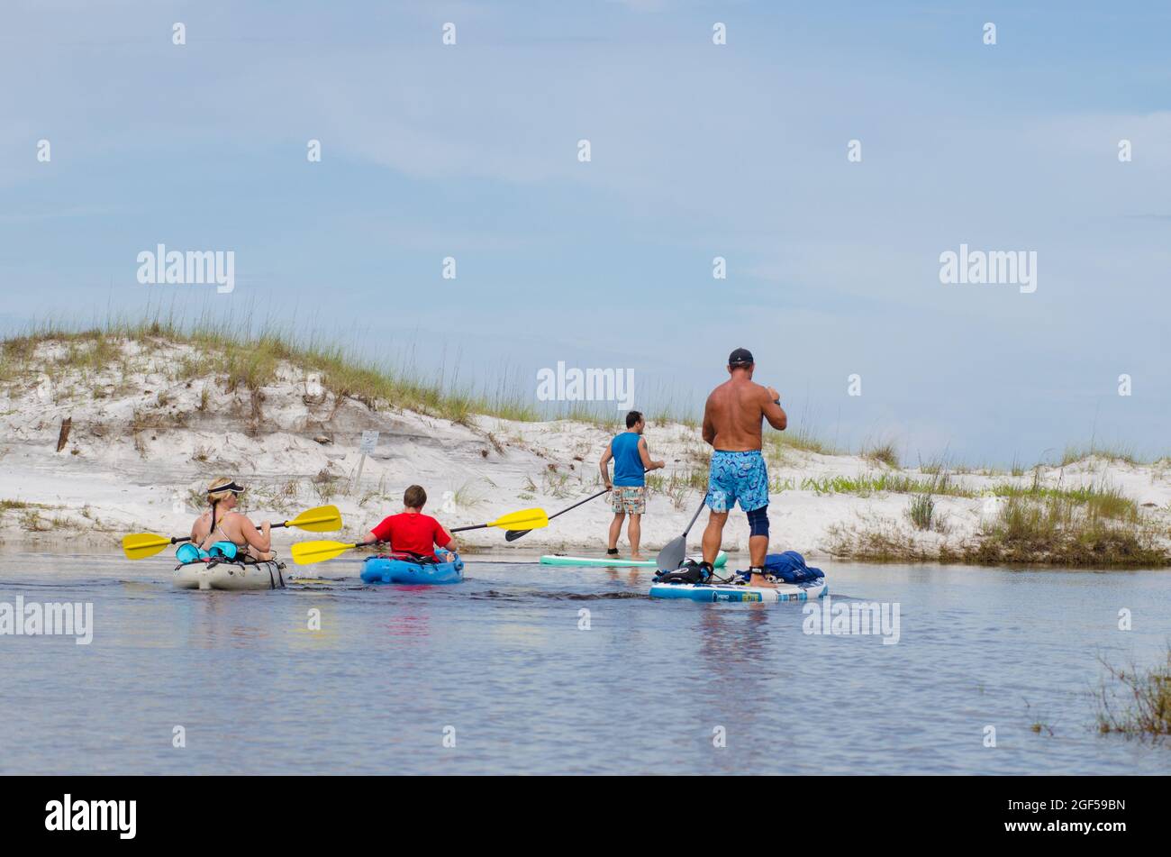 Kayaks and paddle boards paddle along on a coastal dune lake outfall from Western Lake in Grayton Beach State Park, Florida, USA Stock Photo