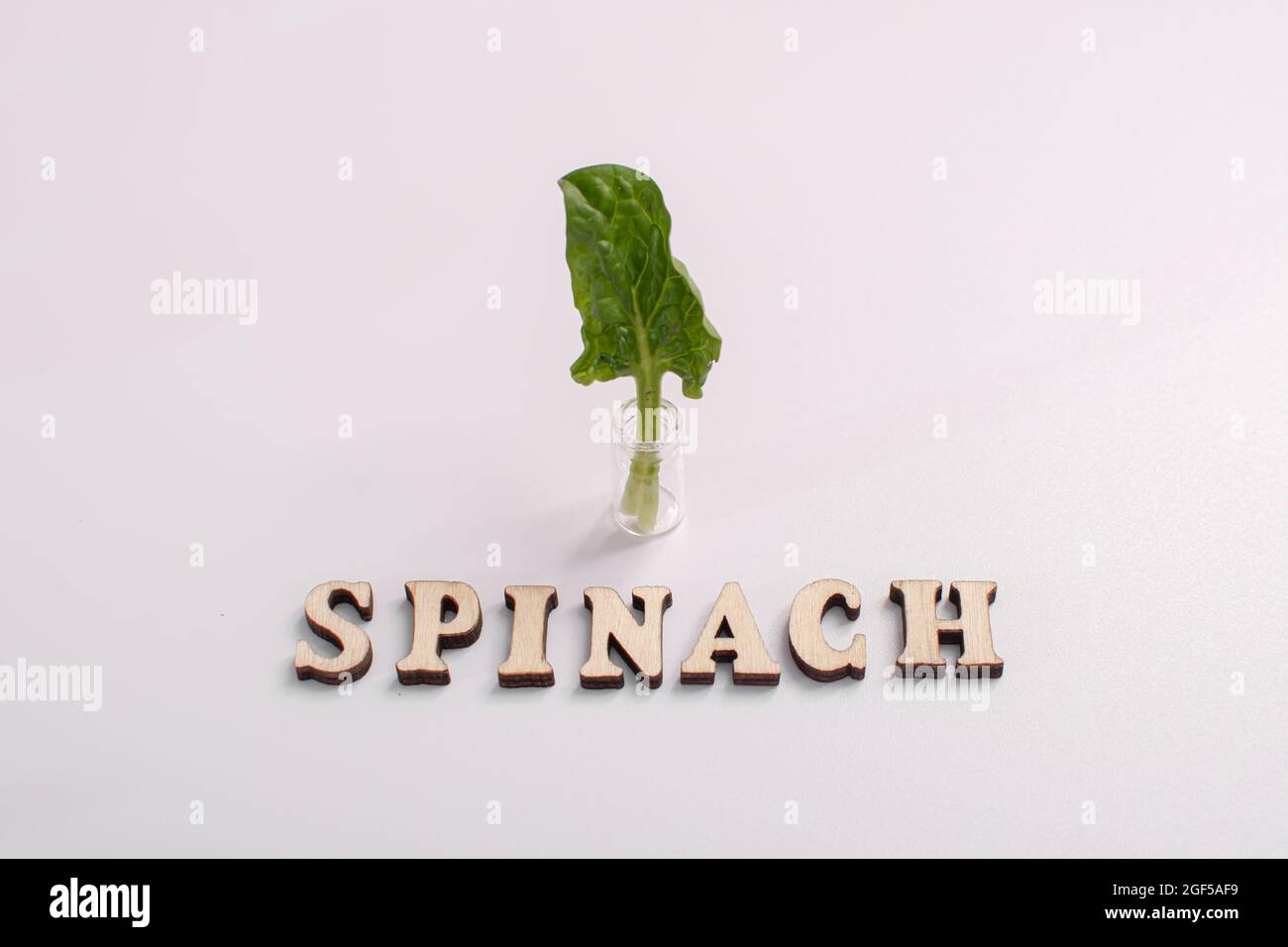 the word spinach is written in wooden letters. Stock Photo