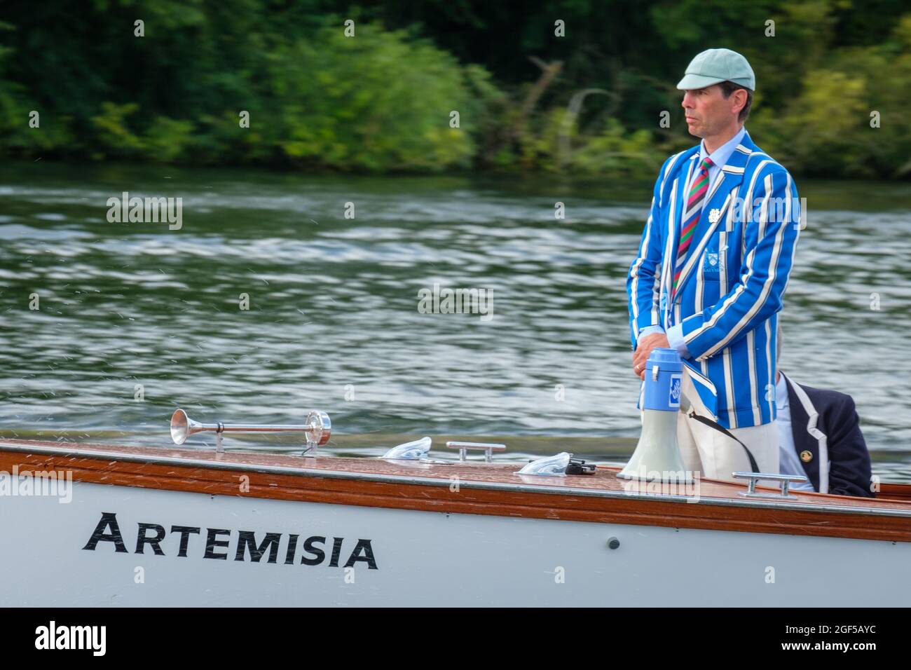 An umpire in a blue and white blazer and blue cap on the Umpire's Launch Artemisia at Henley Royal Regatta 2021 on the River Thames Stock Photo