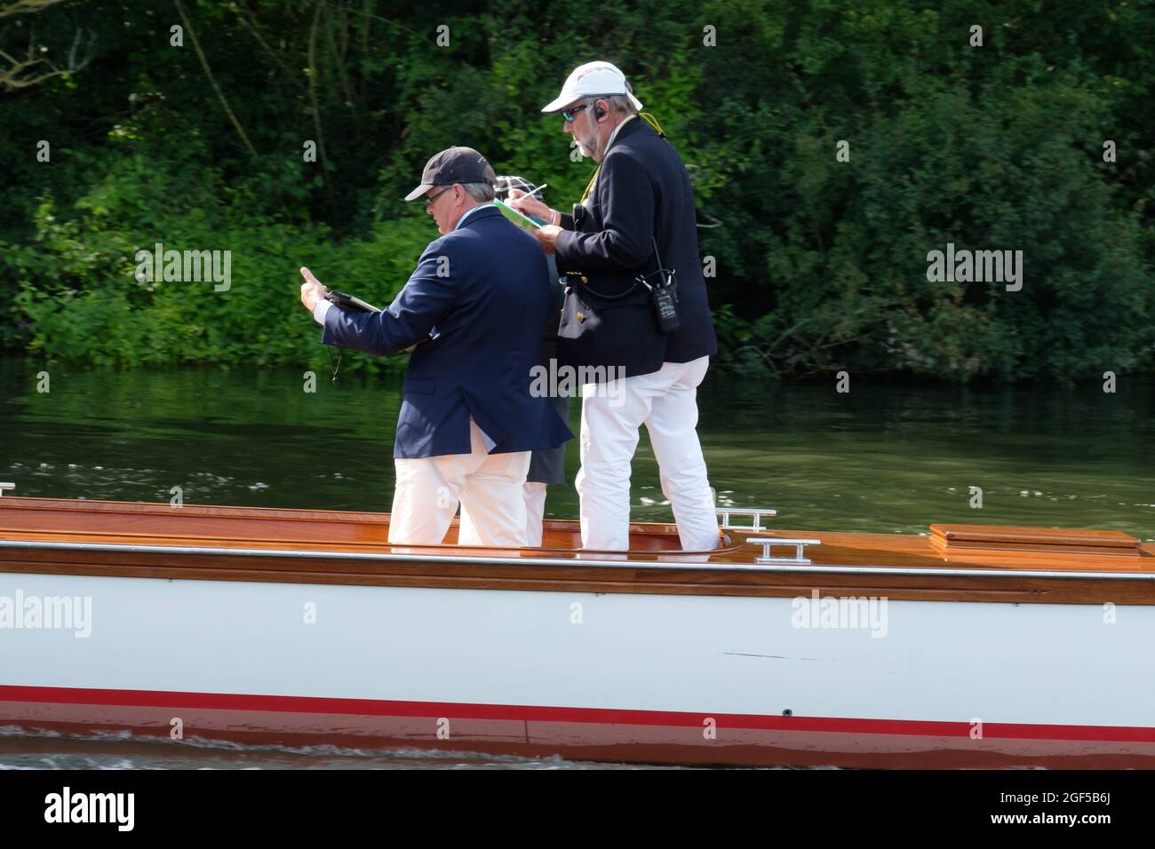 Timekeepers on the Umpires Launch follow a race at Henley Royal Regatta 2021 on the River Thames Stock Photo