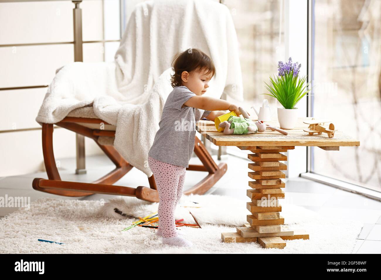 Little girl playing with toys in the room Stock Photo - Alamy