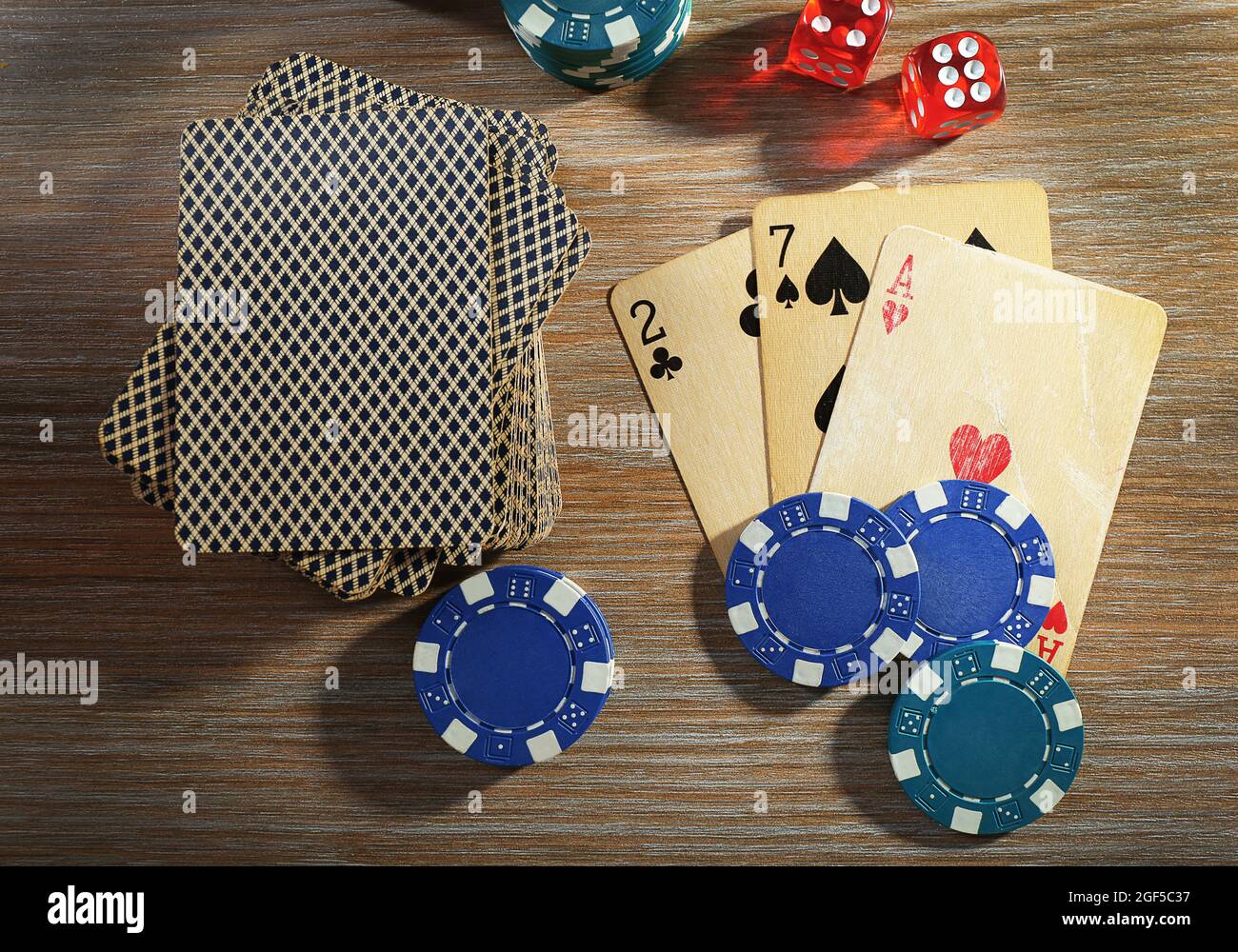 Set to playing poker with cards and chips on wooden table, top view