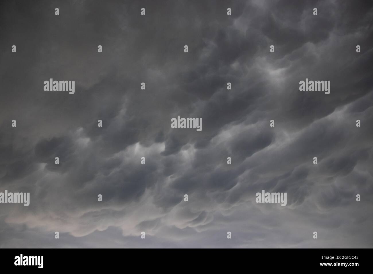 A wide angle cloudscape shot of dramatic clouds in a dark and stormy ...
