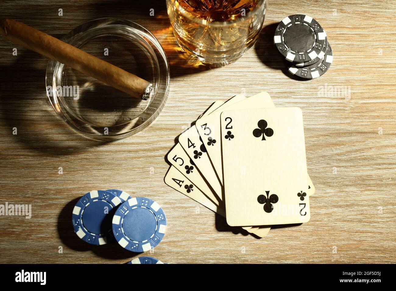 Set to playing poker with cards and chips on wooden table, top view