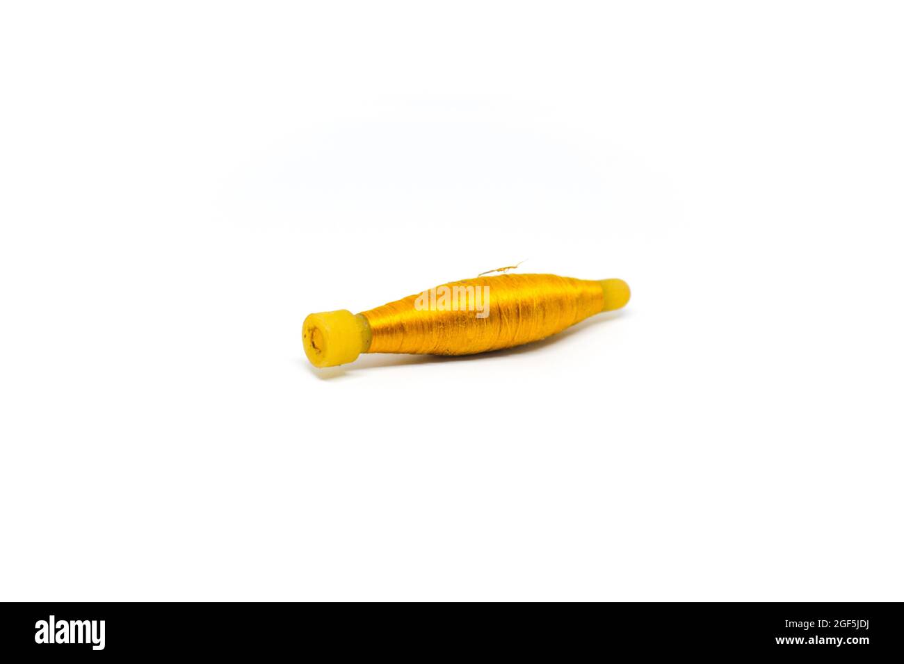 Thin roll of yellow string isolated on a white background Stock Photo
