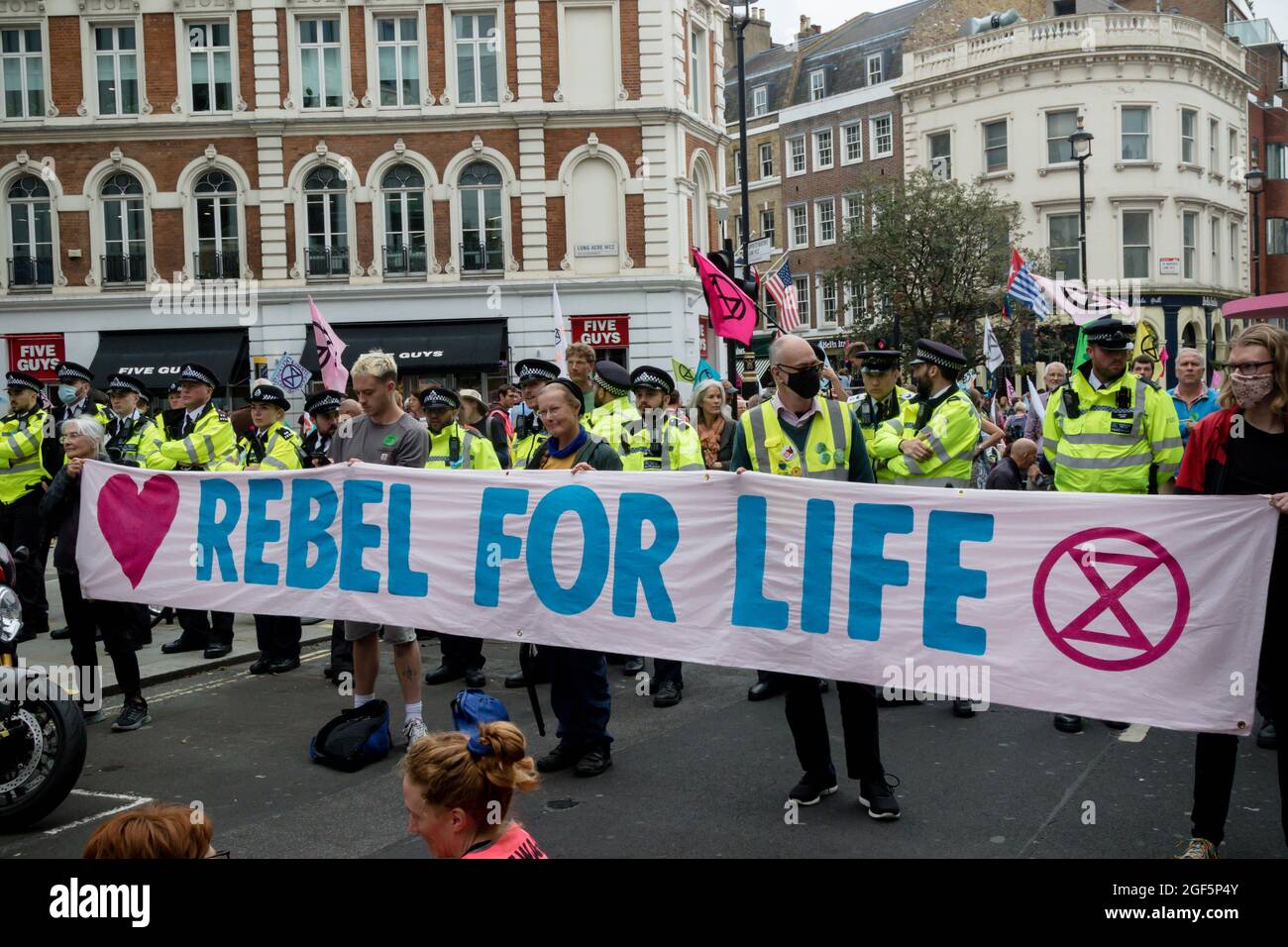 London, United Kingdom, 21st August 2021:- Extinction Rebellion protesters hold a rebel for life banner during a protest in Central London Stock Photo