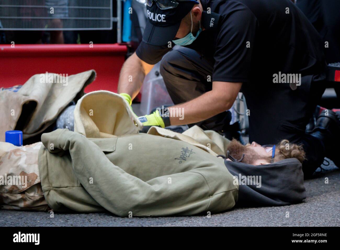 London, United Kingdom, 21st August 2021:- Specialist police officers use cutting equipment to remove Extinction Rebellion protesters from a metal pip Stock Photo
