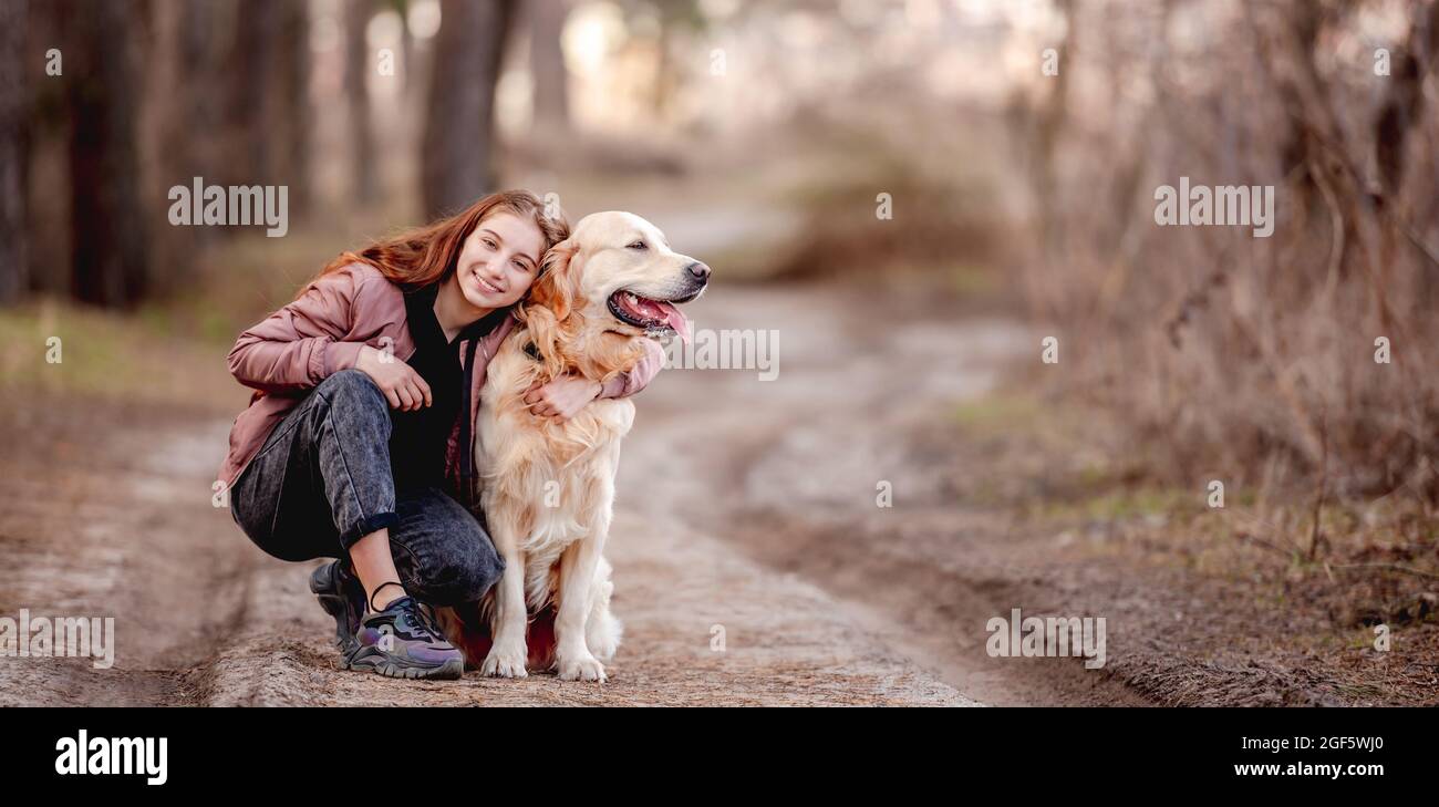 Girl with golden retriever dog in the wood Stock Photo - Alamy