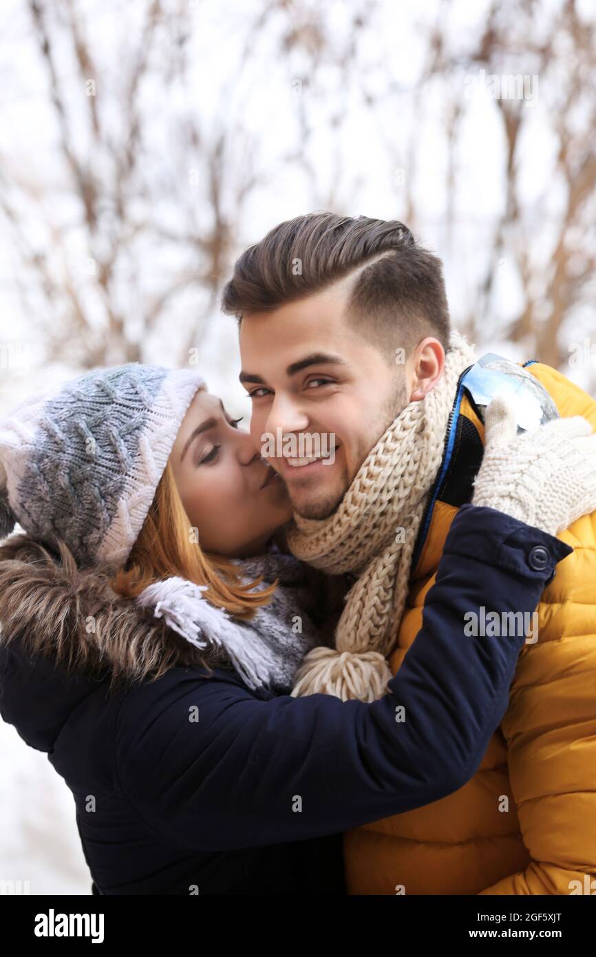Young woman kissing her boyfriend outdoors in winter Stock Photo - Alamy