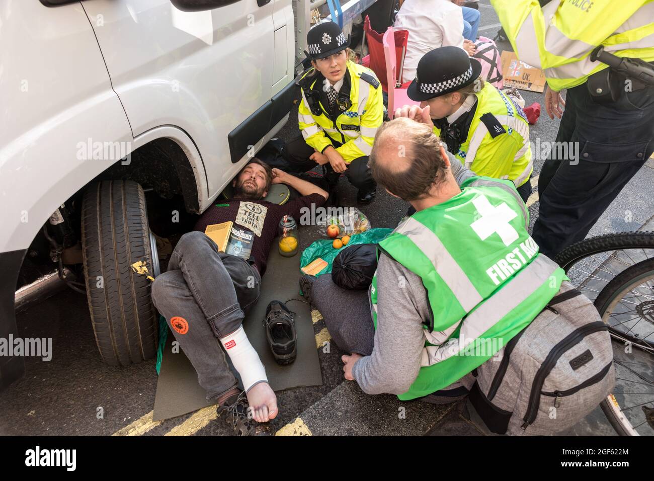 London, UK. 23rd Aug, 2021. Police officers remove and arrest a demonstrator who stuck himself under a van during the protest in Covent Garden.Extinction Rebellion UK initiated a protest in Covent Garden in London to raise awareness of climate change issues, urging the government to take action. Protestors were seen clashing with members of the MET ( Metropolitan ) police force throughout. Some protestors have locked themselves under vans and refused to leave the space. Credit: SOPA Images Limited/Alamy Live News Stock Photo
