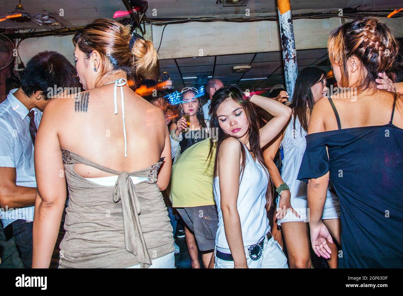 Sexy Thai female wearing white vest gyrating in nightclub, Chiang Mai, Thailand Stock Photo