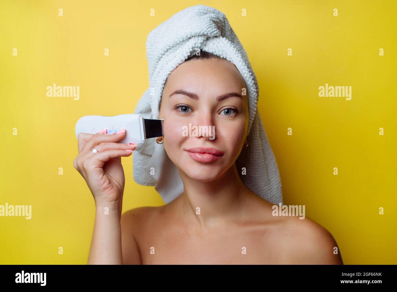 Ultrasonic scrubber for facial skin cleansing. Girl in the bathroom