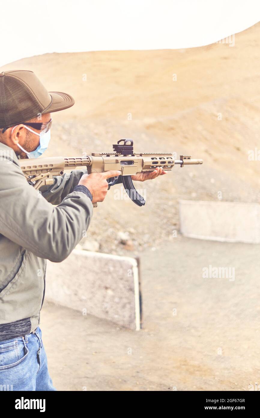 Men practicing shooting with a assault rifle at target. Selective Focus Stock Photo