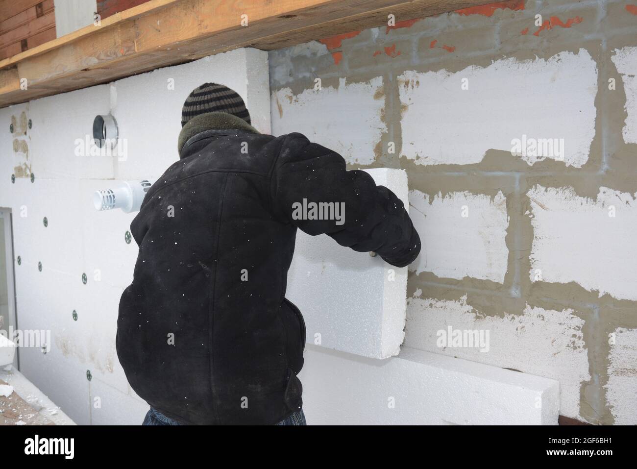 A Building Contractor Is Installing An External Solid Wall Insulation A building contractor is installing an external solid wall insulation