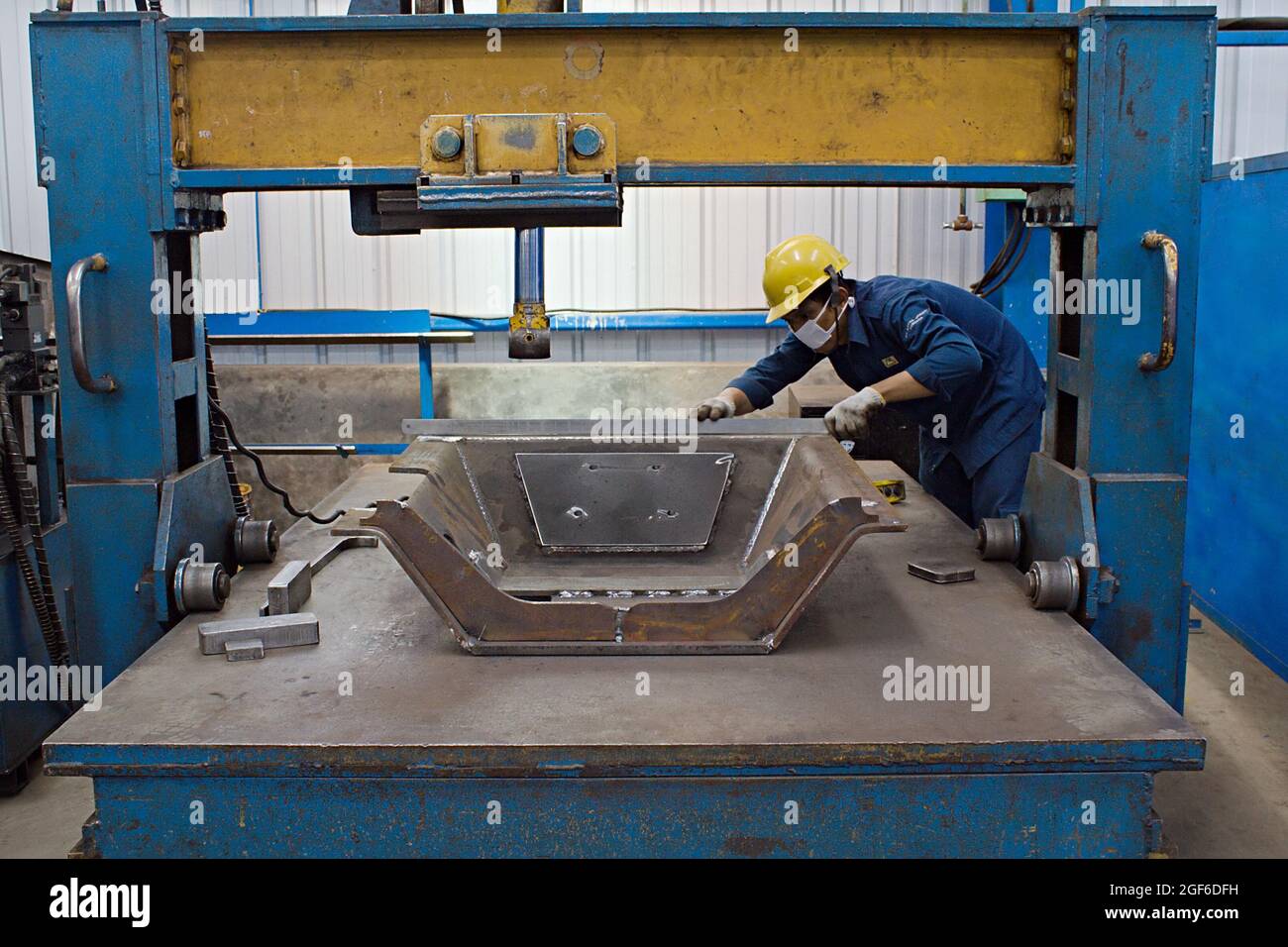 A technician is measuring a prototype tool in a fabrication workshop ...