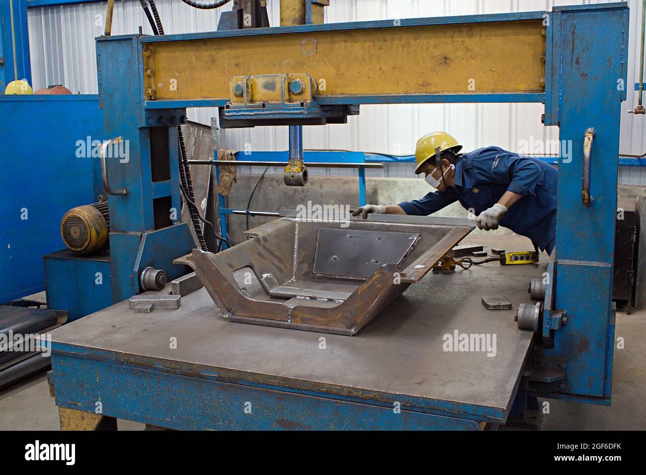 A technician is measuring a prototype tool in a fabrication workshop. Stock Photo
