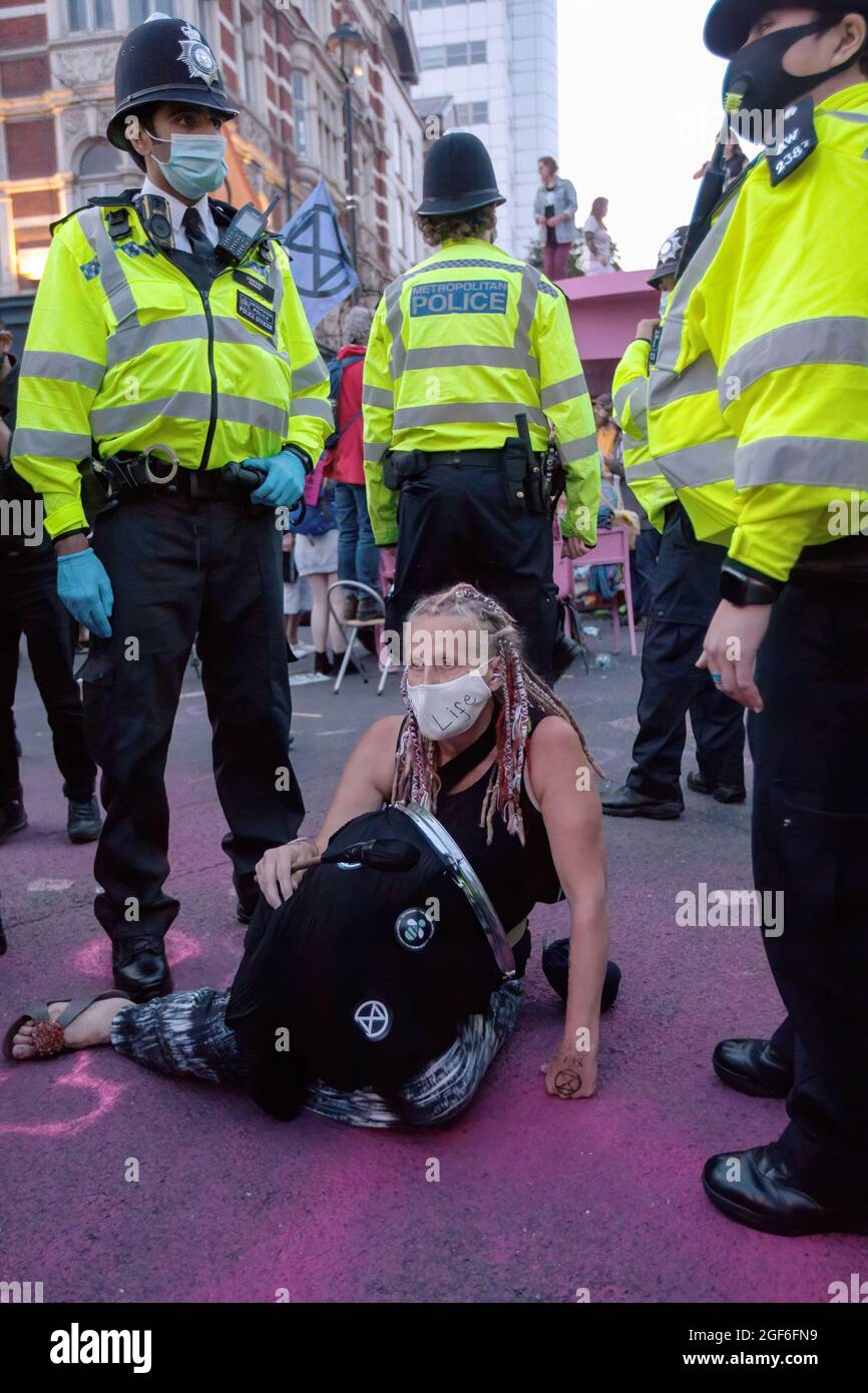 London, UK. 23rd Aug, 2021. Police officers ask all protesters to leave the area under threat of arrest during the demonstration. Protesters from Extinction Rebellion engage in a mass non-violent civil disobedience as part of the 'Impossible Rebellion'. They sat together on the streets and demanded the government to change policies then address the ecological and climate emergency and immediately stop all new fossil fuel investments. Credit: SOPA Images Limited/Alamy Live News Stock Photo