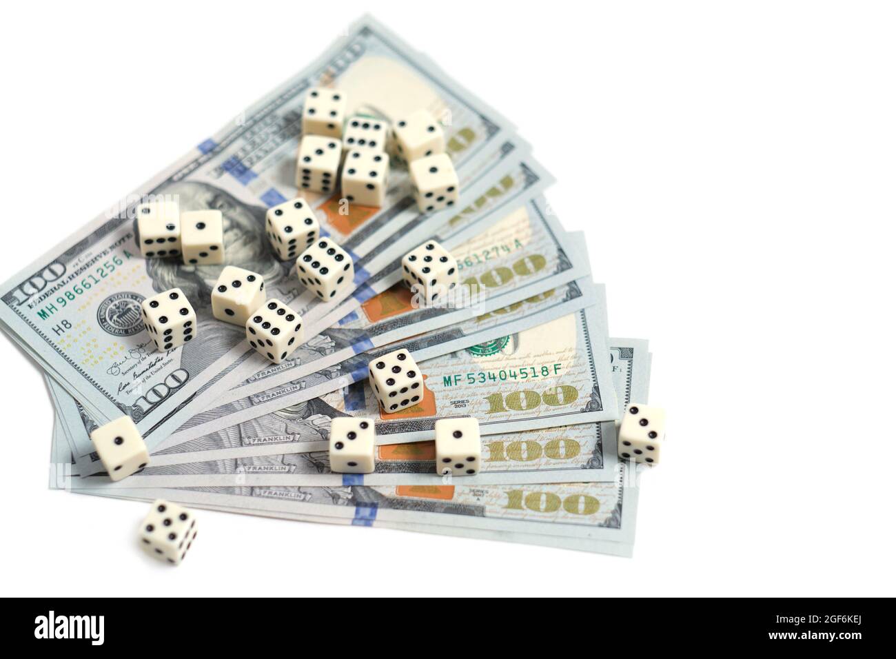 Playing dice and a stack of hundreddollar bills on a white background. Gambling and betting
