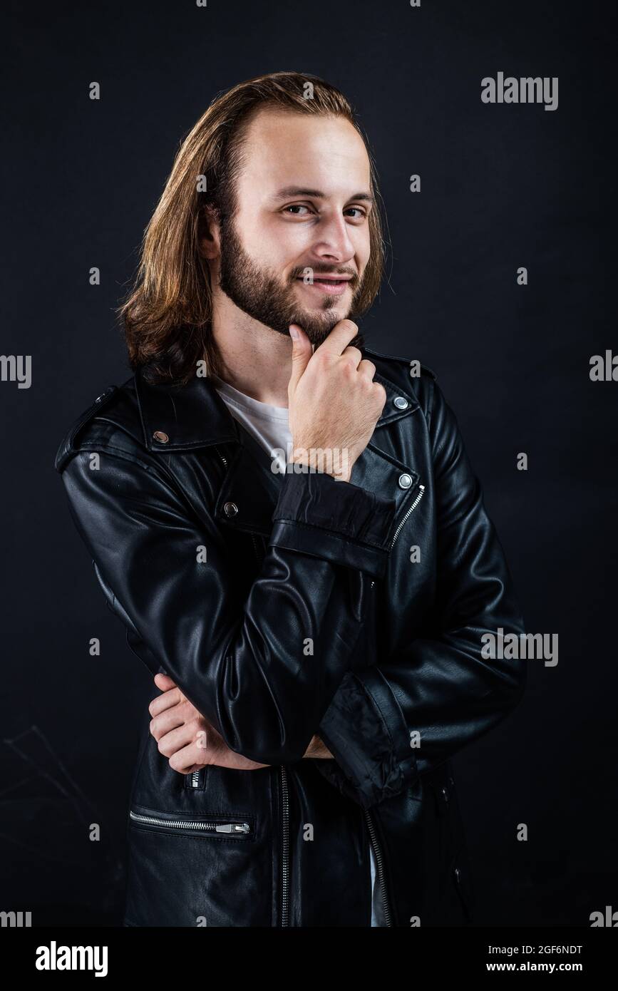 smiling bearded man biker in leather jacket with long hair, punk style ...