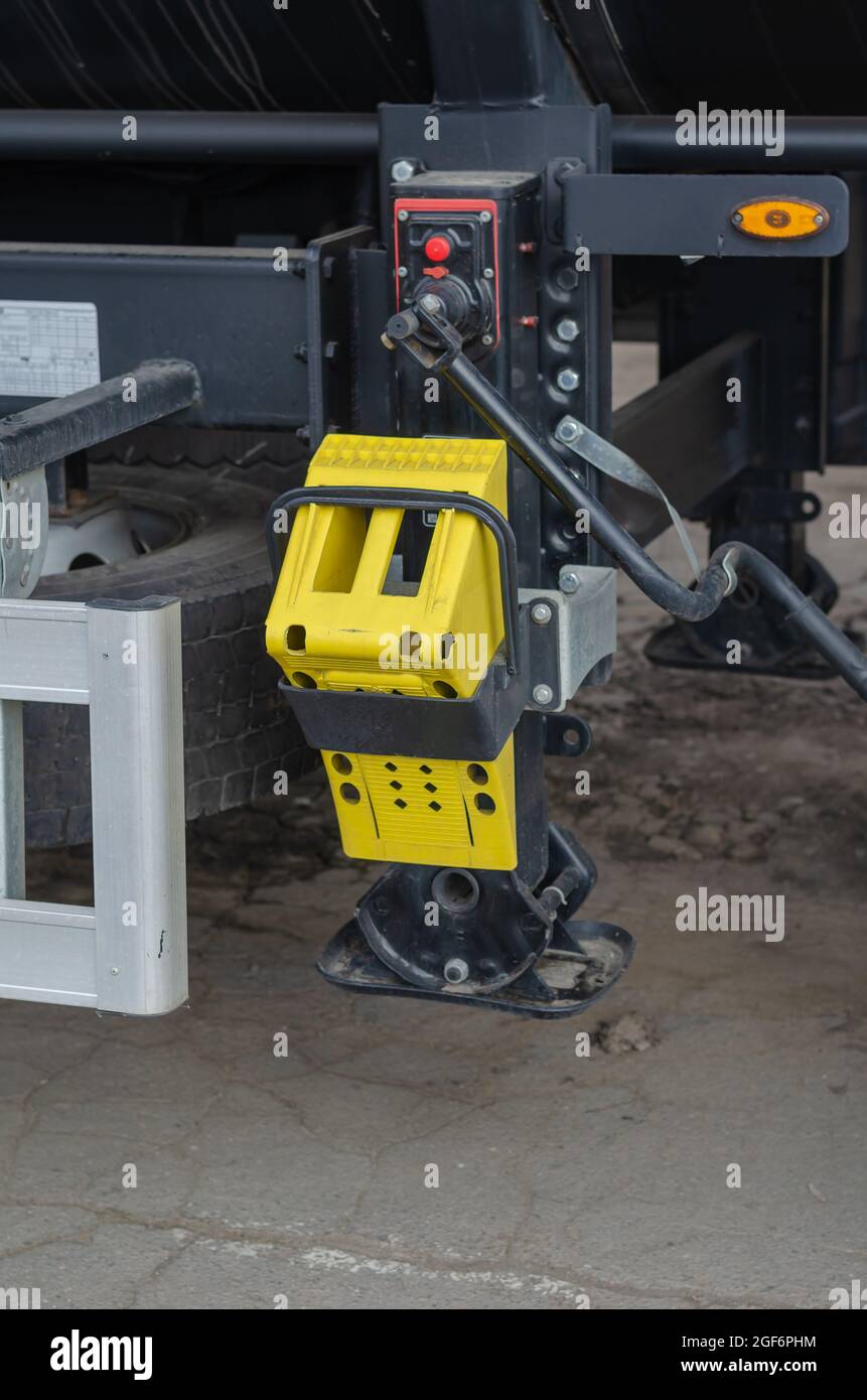 Yellow wheel support fixed to the truck bed. Supports for semitrailers with handle. Transport