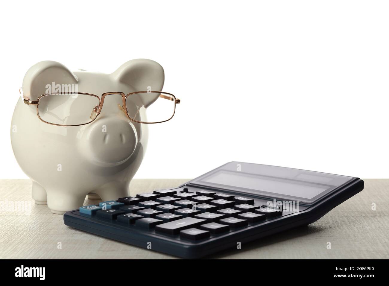 Piggy bank with glasses and calculator on white background Stock Photo ...