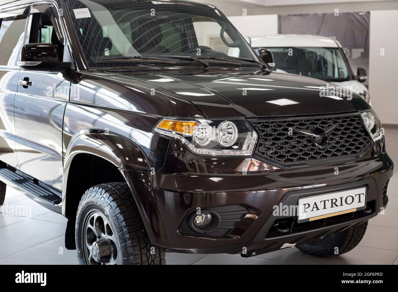Russia, Izhevsk - August 20, 2021: UAZ showroom. New UAZ Patriot car in dealer showroom. Sollers automotive group. Front and side view. Cropped image. Stock Photo