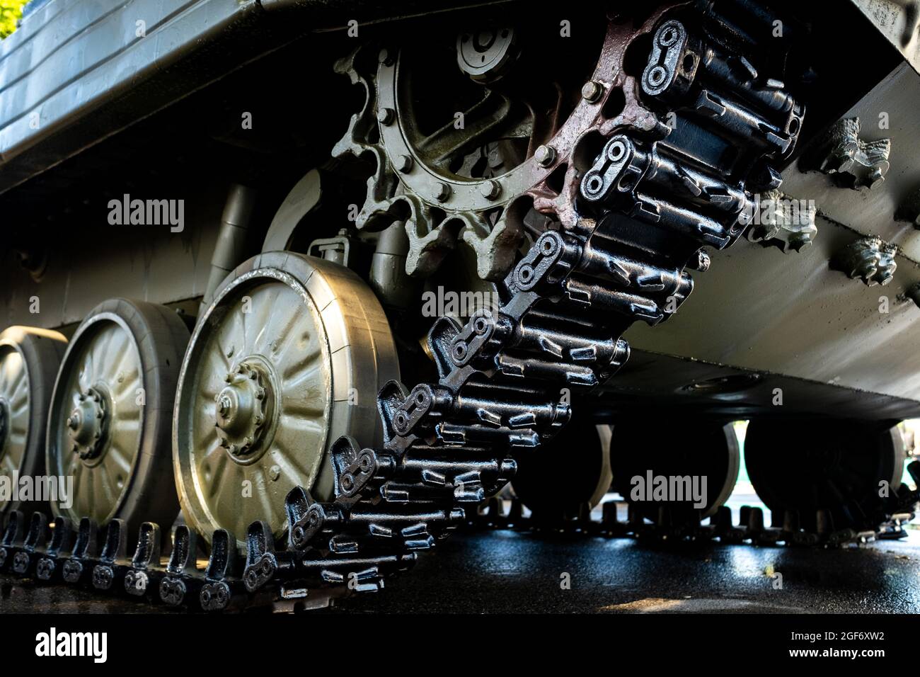 Tracked armor close-up. Black link tracks and large rubberized rollers. Chassis of an infantry fighting vehicle Stock Photo