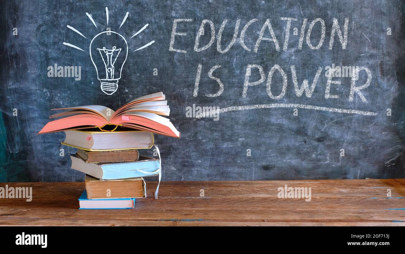 books and blackboard with drawing of a lightbulb and slogan education is power,learning,knowledge,back to school concept Stock Photo