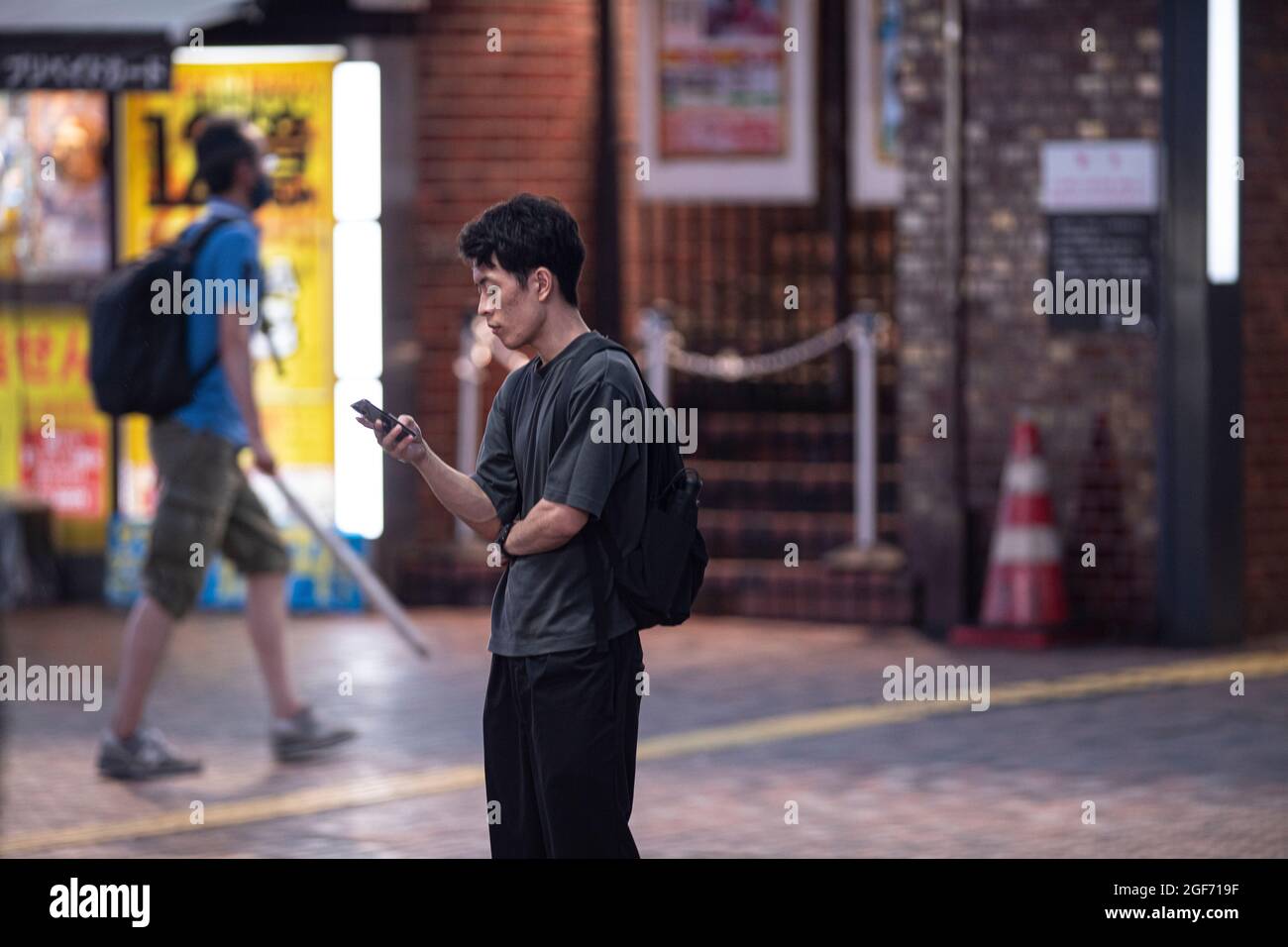 People on the street of Tokyo looking at their mobile phone and their social networks. Stock Photo