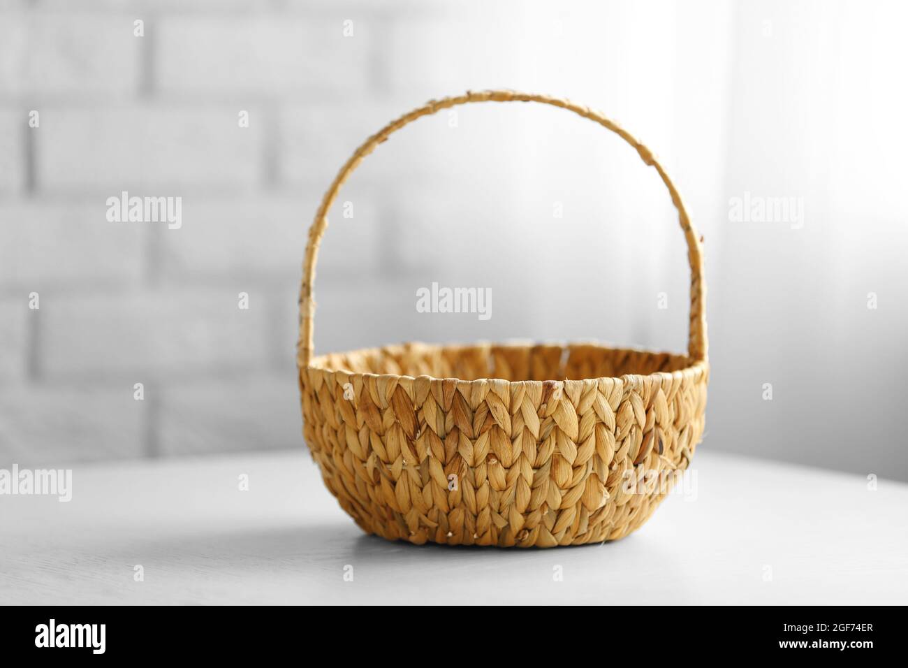Wicker basket with handle on wooden table, closeup Stock Photo Alamy