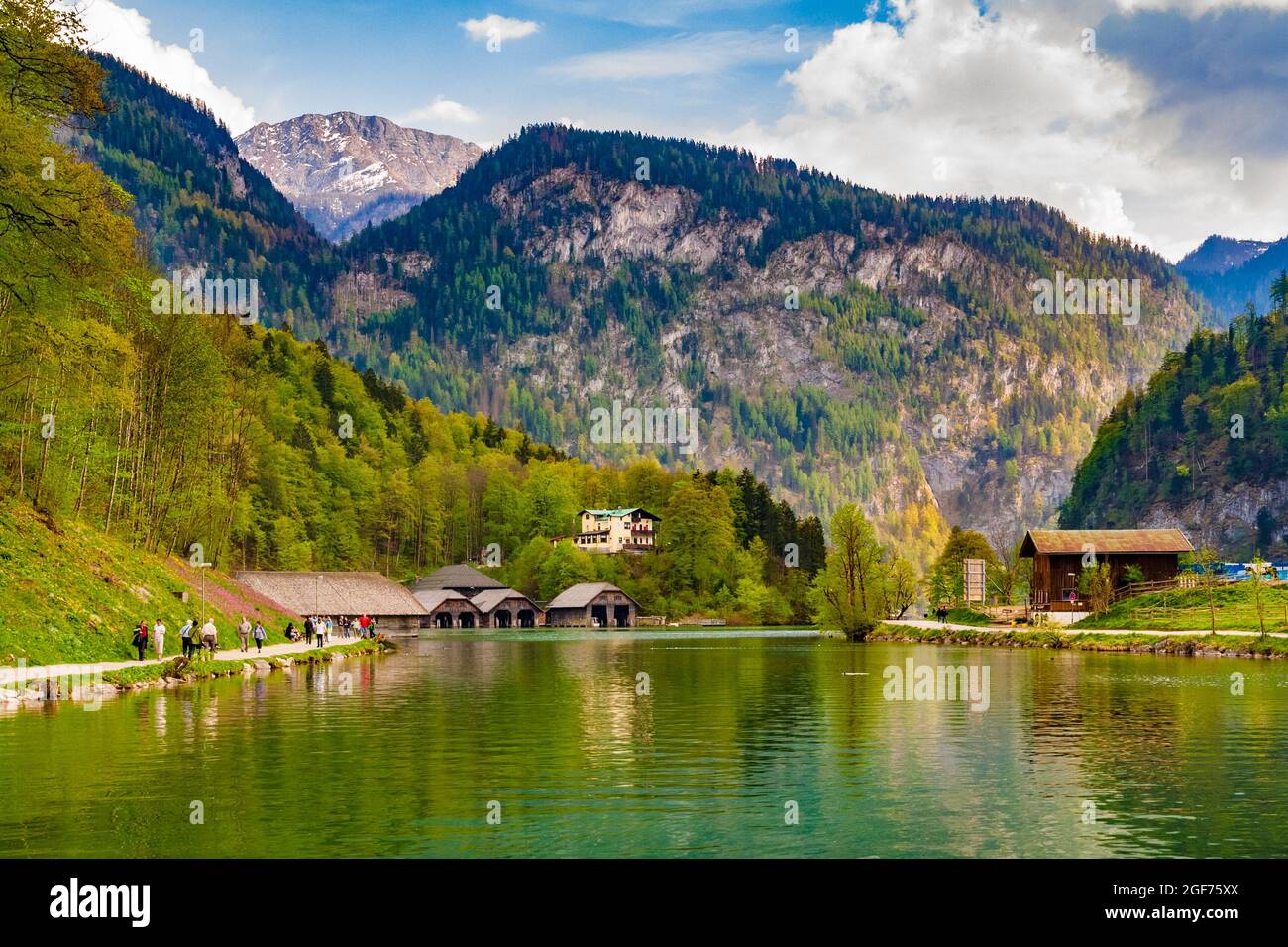 Picturesque landscape view of the northern end of the Königssee lake surrounded by mountains in Bavaria, Germany. In front is a row of boathouses and... Stock Photo