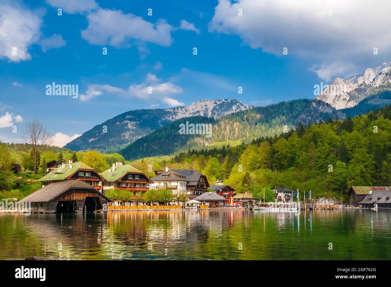 Gorgeous panoramic view of the municipality Schönau am Königssee with traditional Bavarian houses, boathouses, a boat at the pier of the lake and the... Stock Photo