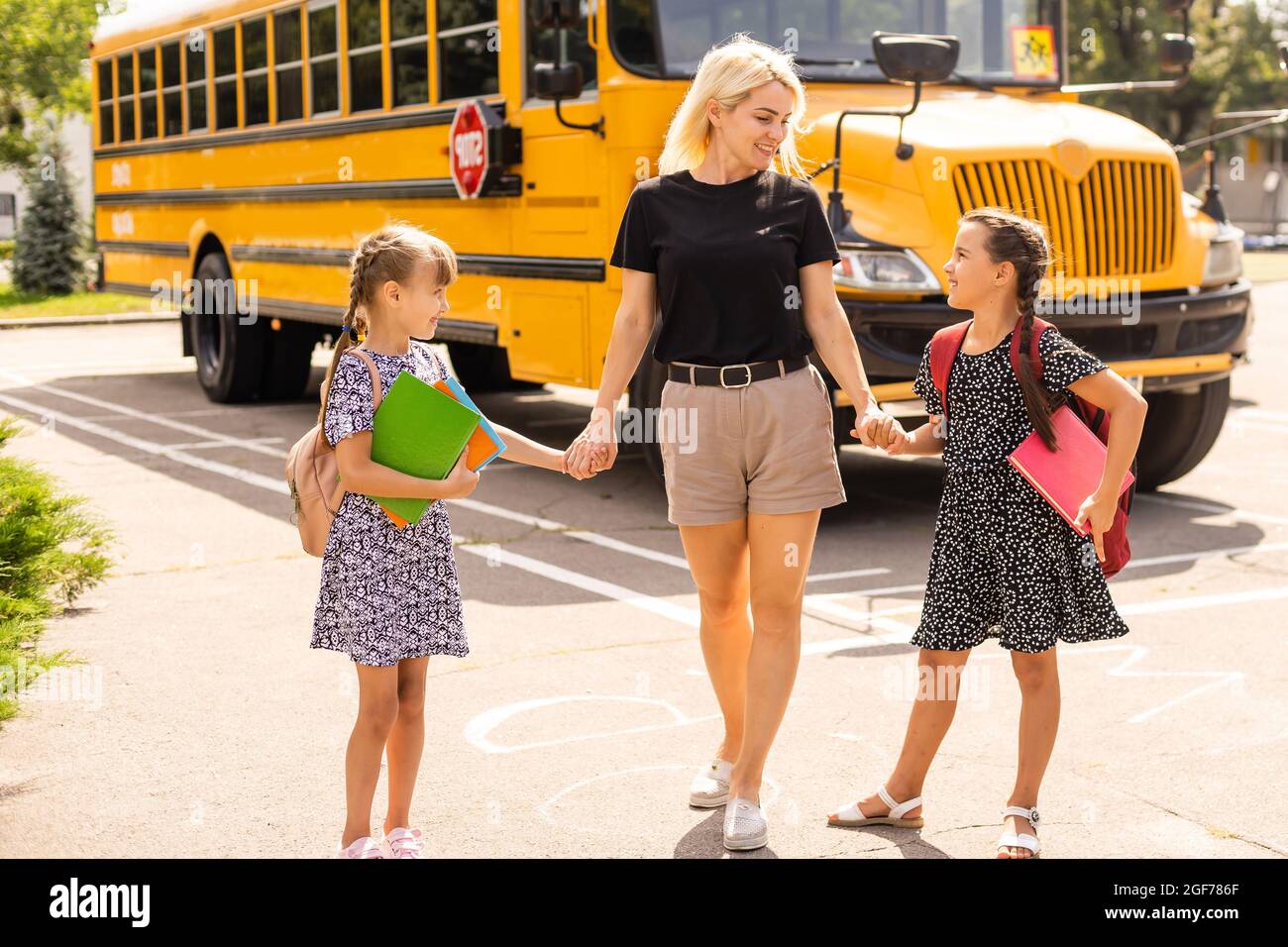 Back to School Concept. mother saying goodbye to her daughters. go to school. Back to school concept. Child from elementary school. Education concept. Stock Photo
