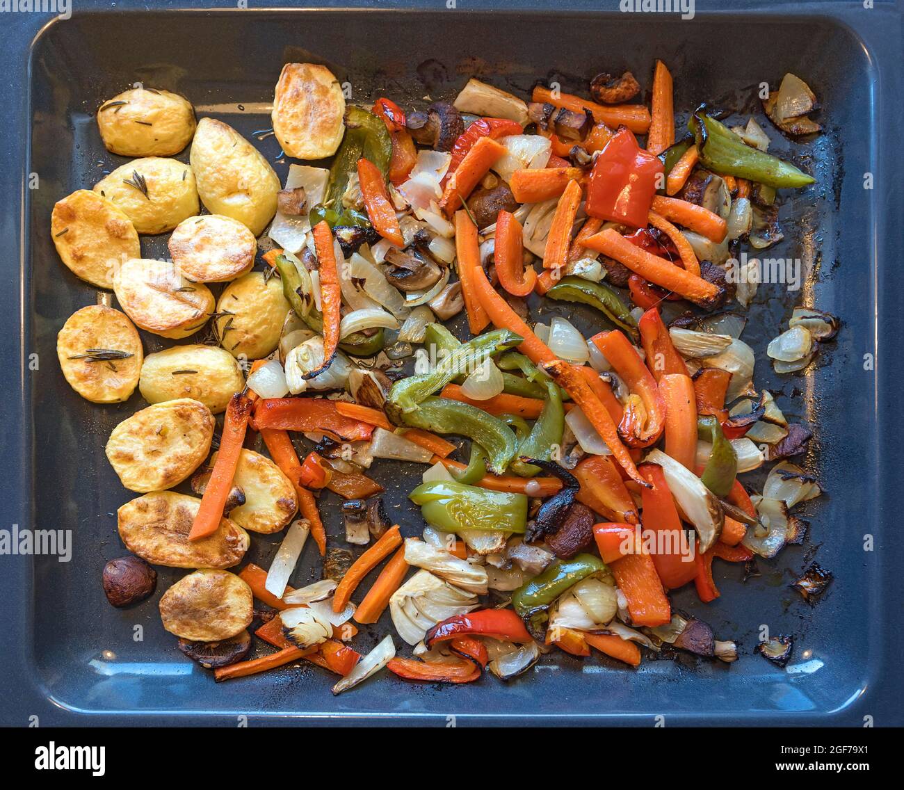 Rosemary potatoes and mixed vegetables on a baking tray, Germany Stock