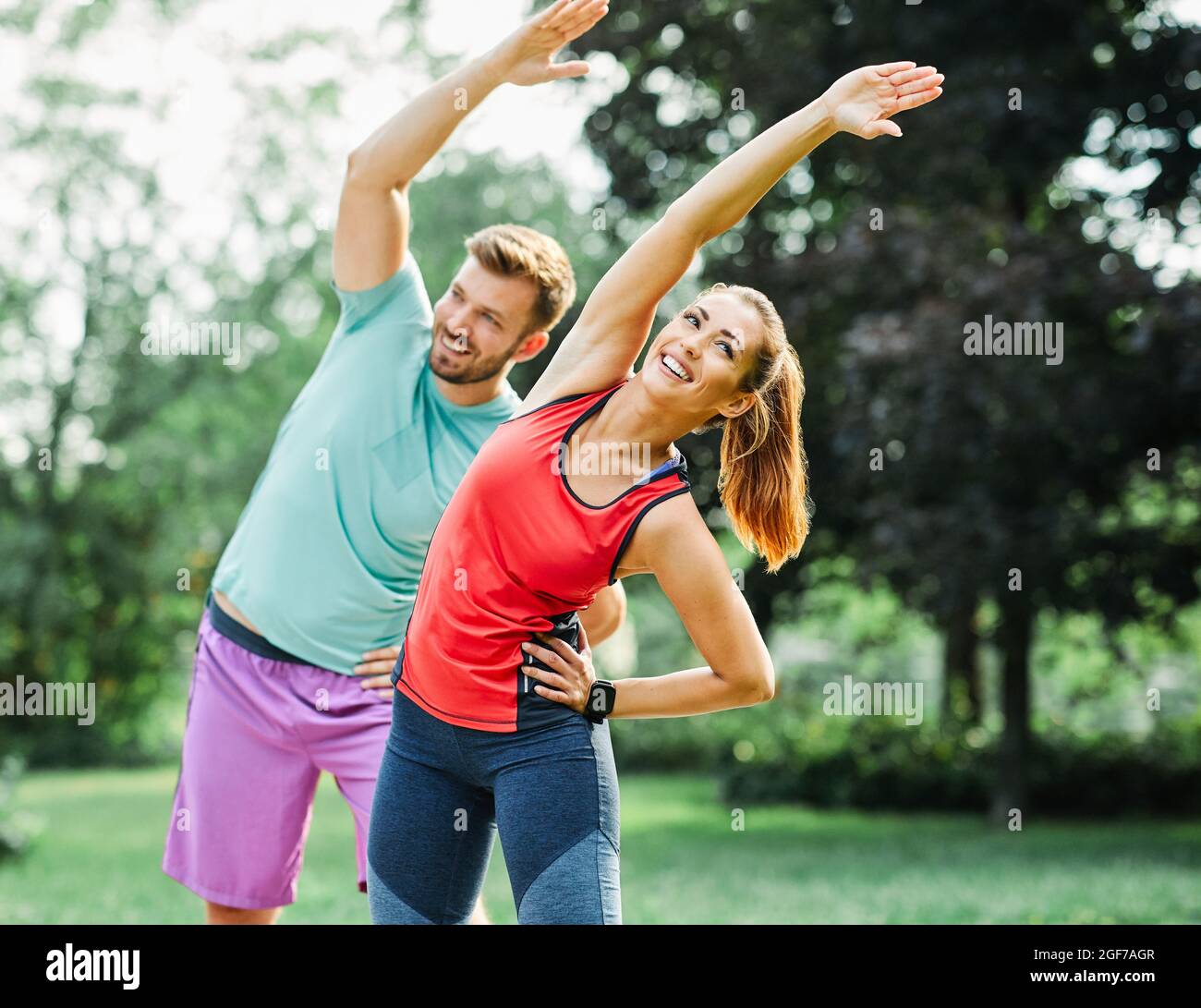 fitness woman park exercise lifestyle outdoor sport healthy couple stretching young fit training athlete Stock Photo