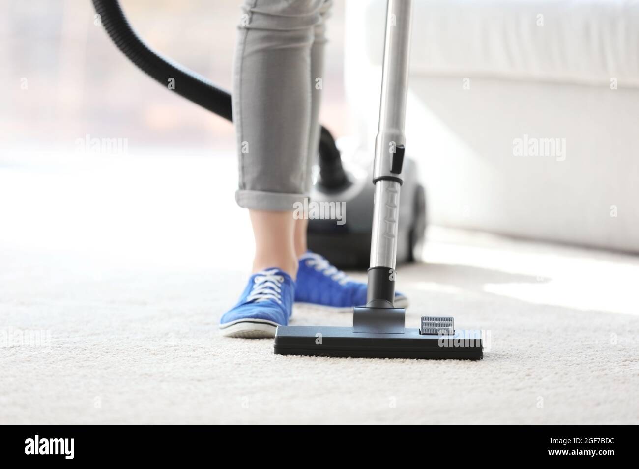 Cleaning concept. Young woman cleaning carpet with vacuum cleaner ...