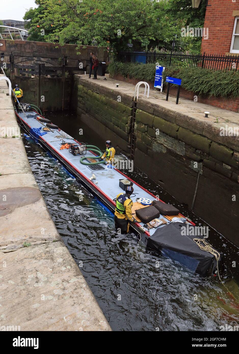 Water is starting to be pumped from a sunken canal boat from lock 92 of the Rochdale canal to re float it. This is image 3 of the rescue operation Stock Photo