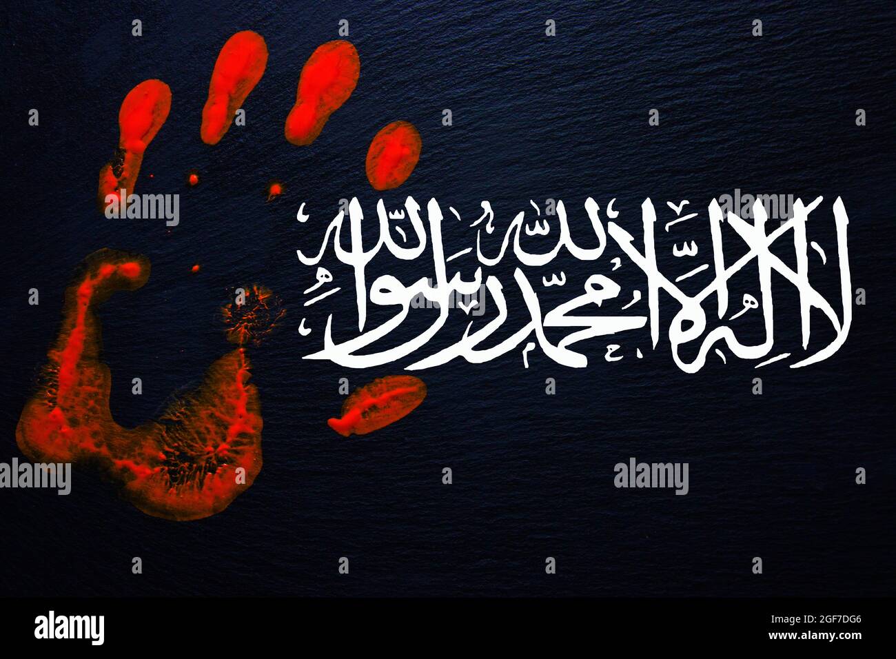 Slate with a bloody handprint and the flag of the Taliban with the inscription, There is no God but Allah, Mohammed is his messenger, Germany Stock Photo