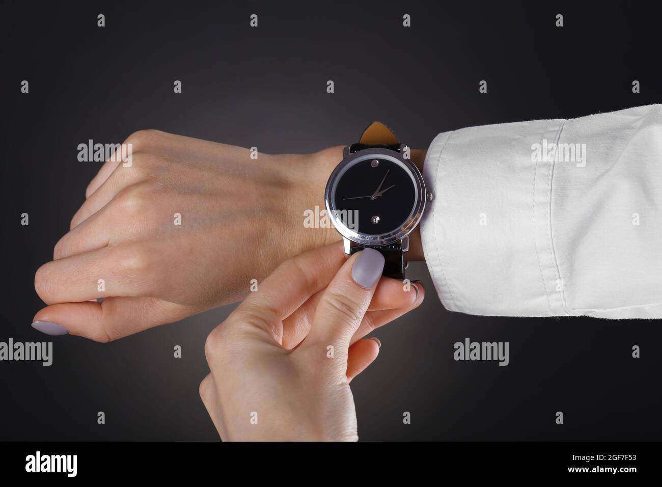 Modern watch on a woman’s wrist over black background Stock Photo - Alamy