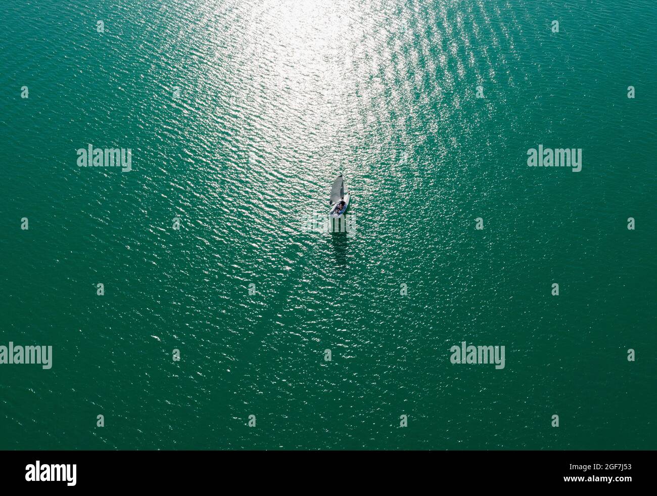 Drone shot, sailboat from above at the lake in backlight with water reflection, Mondsee, Salzkammergut, Upper Austria, Austria Stock Photo